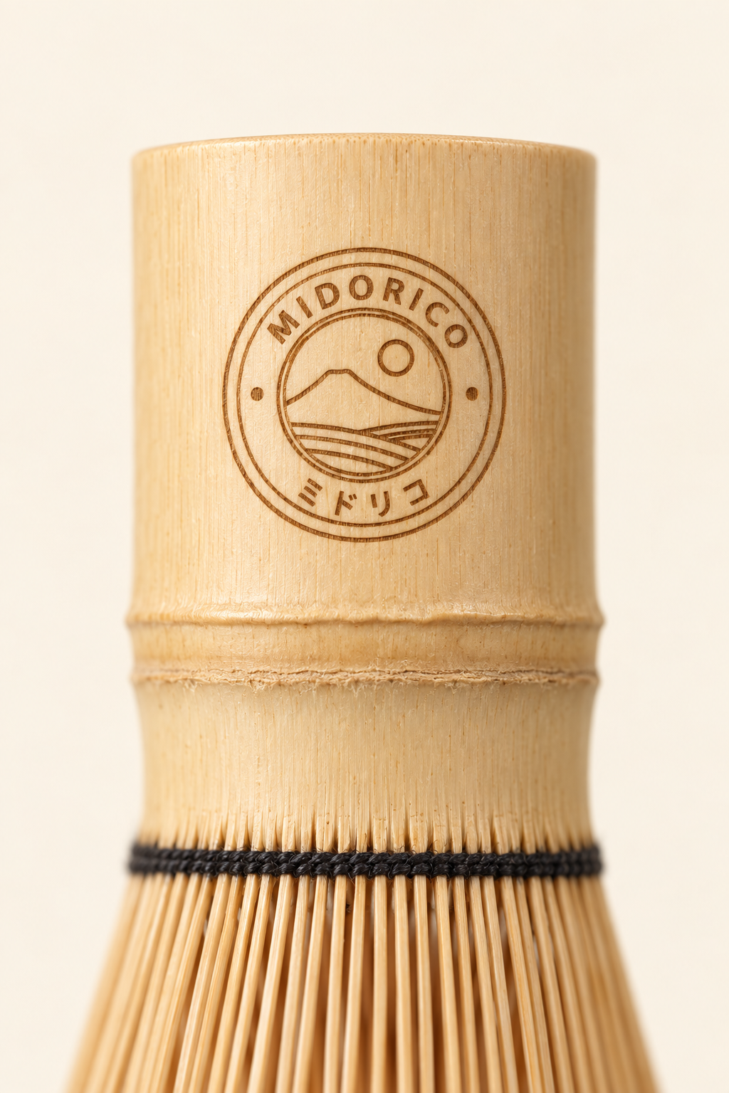 Close-up of the laser-engraved Midorico emblem on the bamboo whisk handle